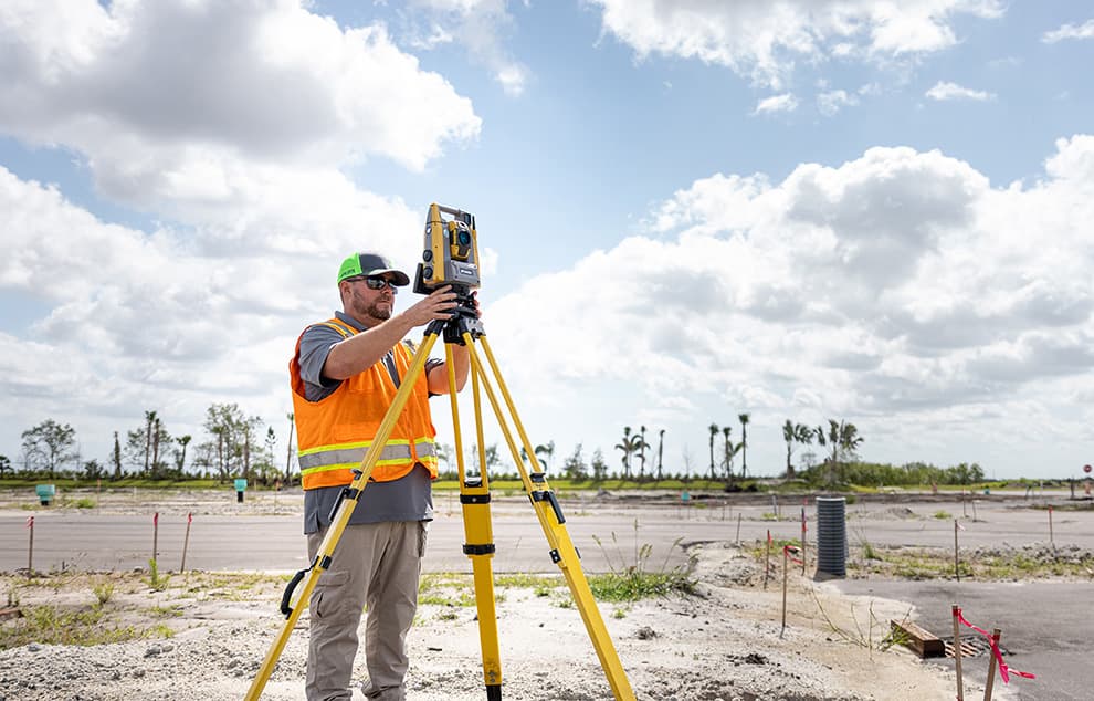 Surveyor using a total station outdoors